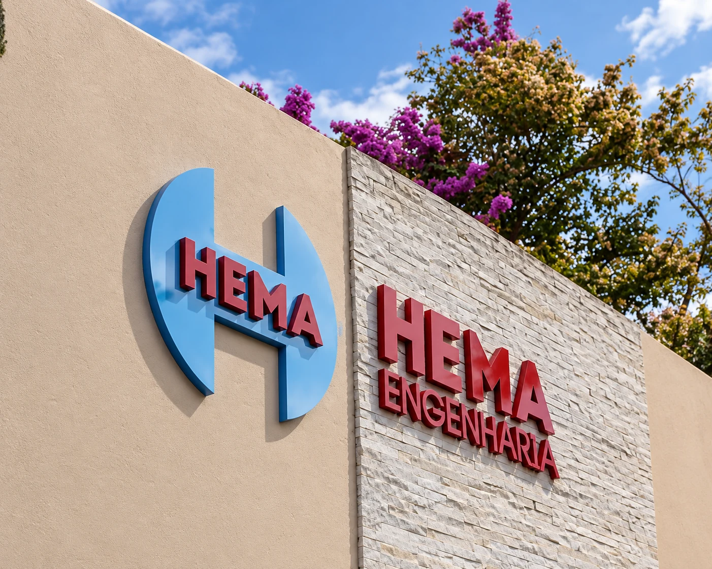 Símbolo azul e letras vermelhas em relevo da HEMA Engenharia